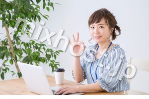 パソコンをしながらokサインをする女性